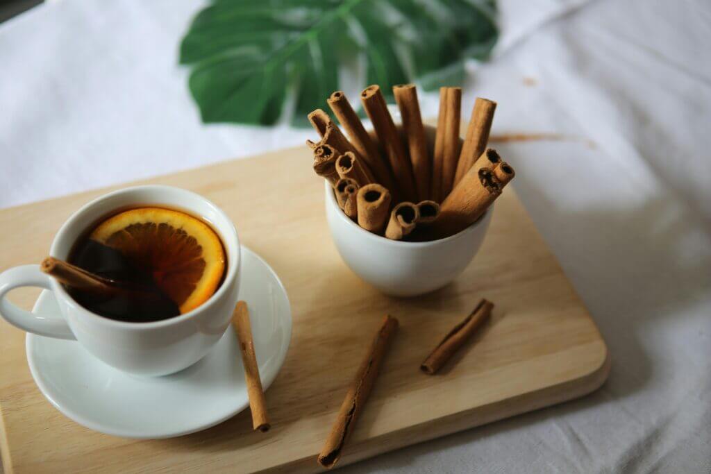 natural remedies to Prevent Diabetes cinnamon sticks and warm orange tea on a wooden surface.